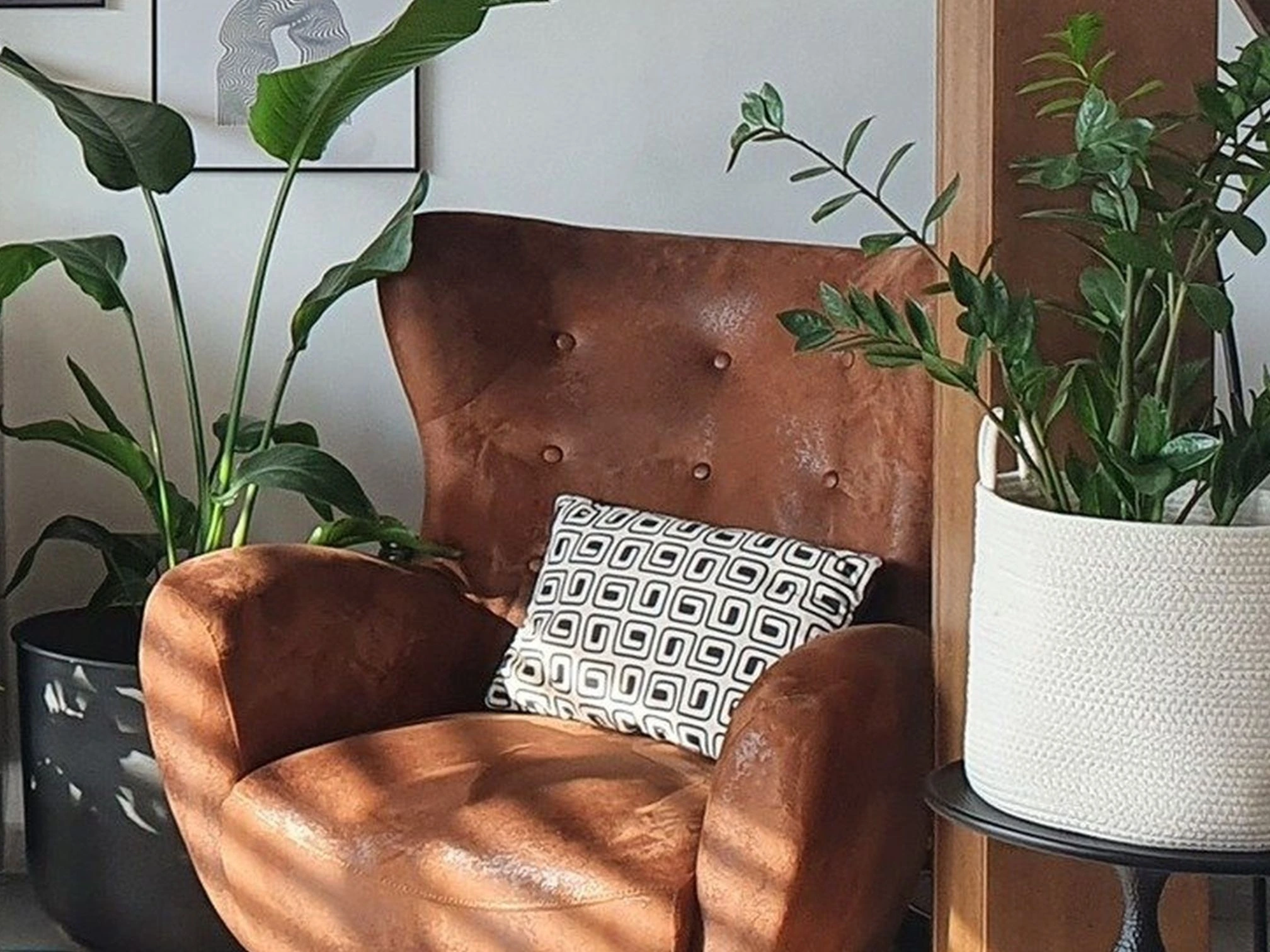 Obývací pokoj s dřevěným schodištěm, rostlinami a pohodlným křeslem ve stylu feng shui.